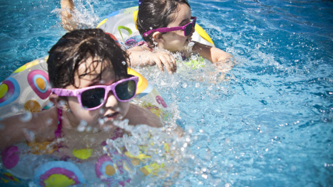 Children swimming with sunglasses on