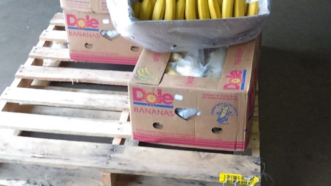 Boxes of bananas sitting on a pallet in a warehouse