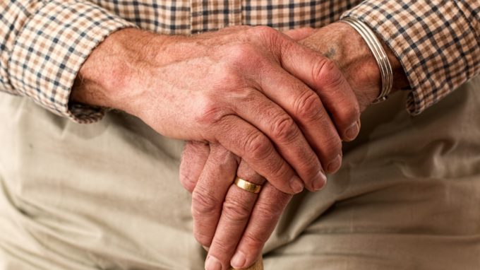 Older man's hands on a cane