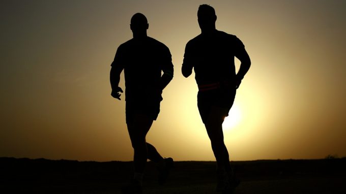 Two men running at sunrise