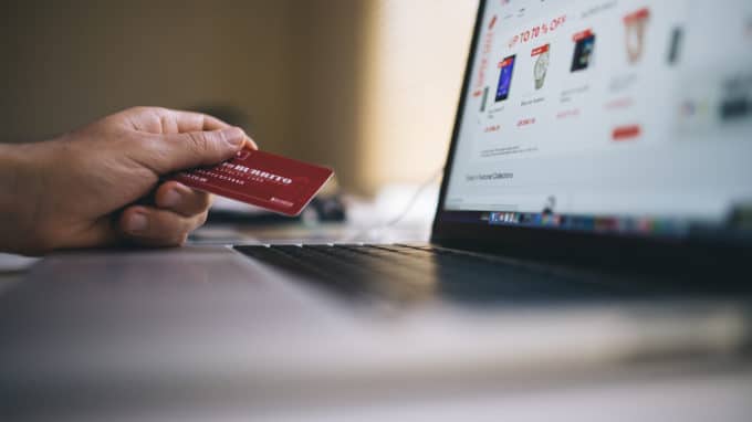 Person sitting at computer about to buy something with their credit card