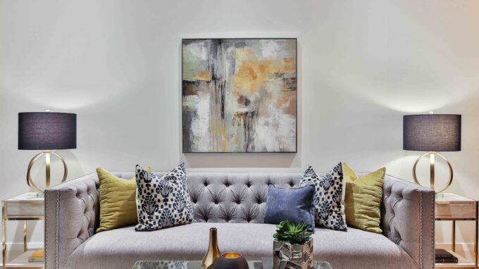 Picture of a living room with a couch, coffee table, side tables, lamps and a painting.