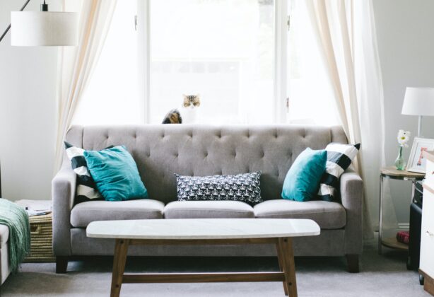 grey couch with teal pillows