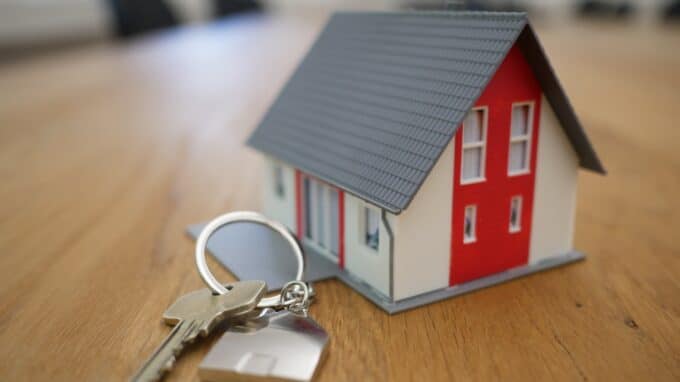 Miniature house next to keychain on a table