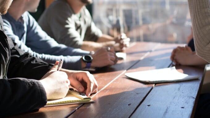 Group of coworkers sitting at a wood table.