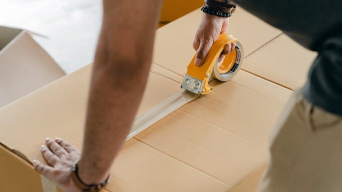 Man tapes up moving box