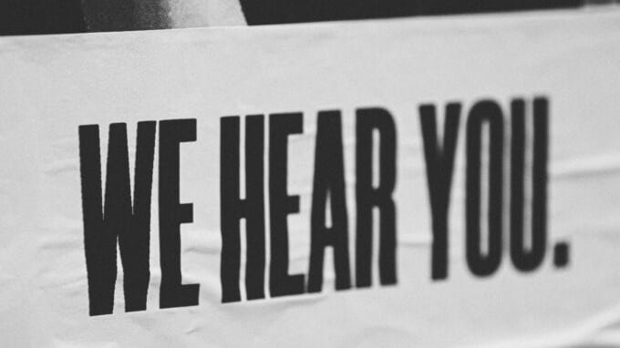 Black and white picture of a banner that says We Hear You.