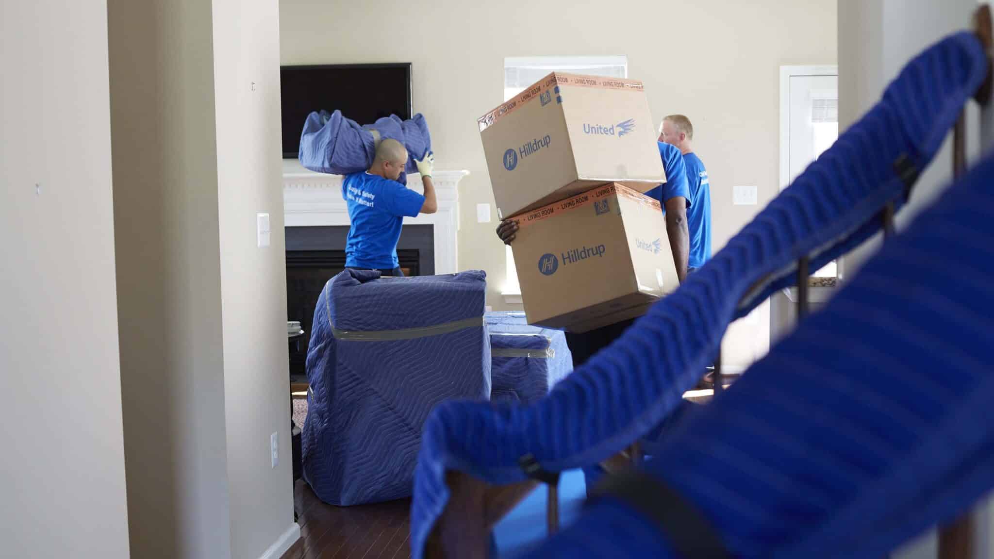 Hilldrup movers carrying boxes and furniture. 