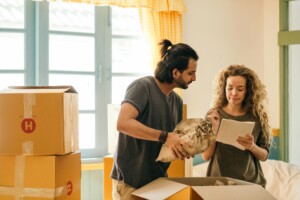 couple reviewing checklist surrounded by moving boxes
