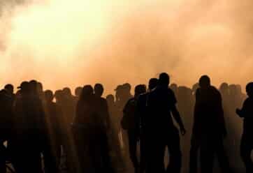 Silhouette of people in a crowd with smoke