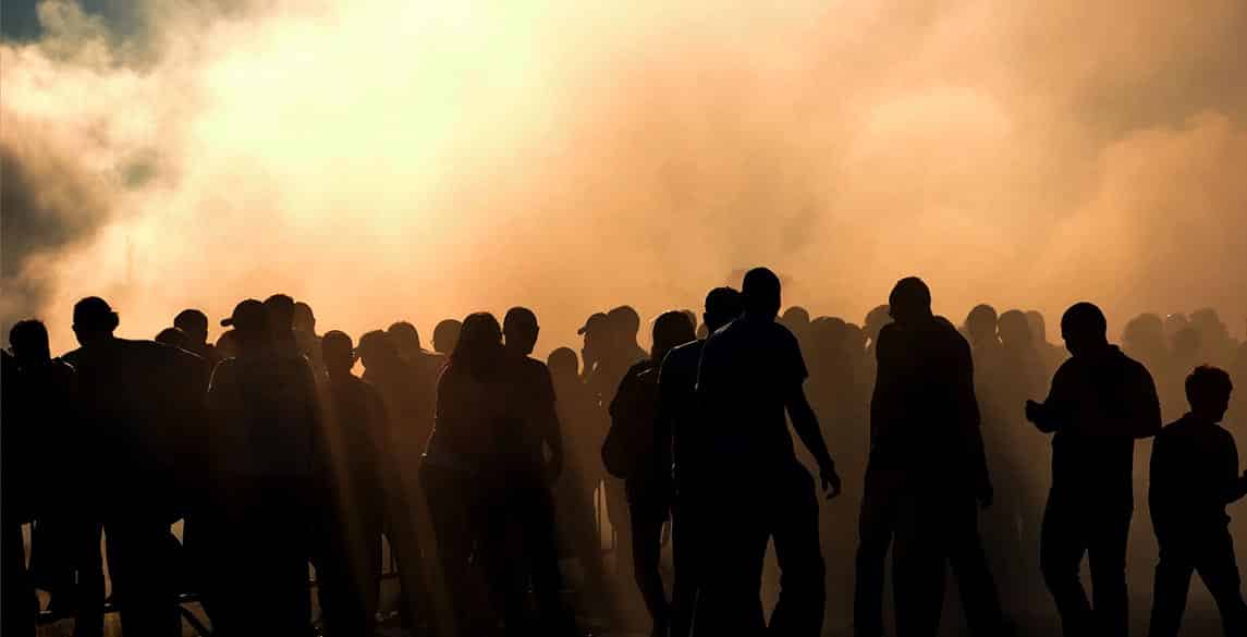 Silhouette of people in a crowd with smoke