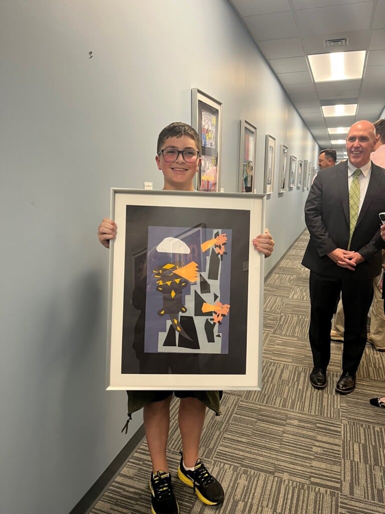 Student artist with artwork at Stafford HQ 