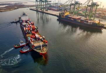 Overhead shot of cargo ship with shipping containers close to port