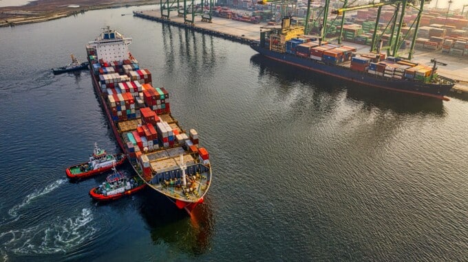 Overhead shot of cargo ship with shipping containers close to port