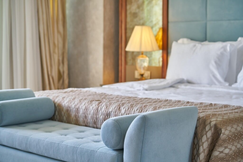 Image of a hotel bed and  an end-of-bed bench. 